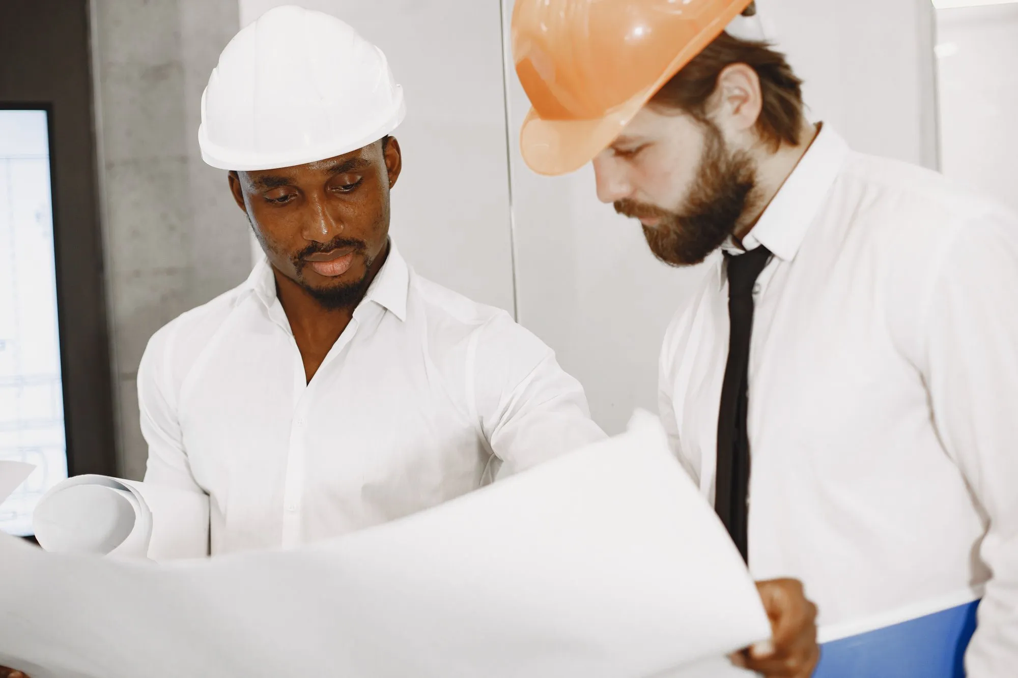 Profesionales con cascos revisando un plano; imagen de referencia, no es el equipo de DyF.